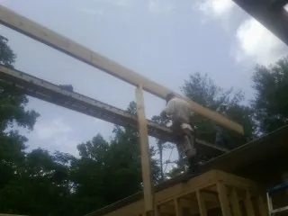 Carpenter setting a ridge beam over a new addition frame — Ice Dam Removal by Roofing Brothers in Parkhill