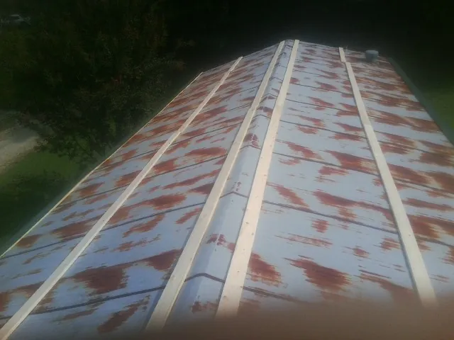 Rusted metal roof panels with new wood purlins before replacement — Storm Damage Roof Repair in Parkhill by Roofing Brothers