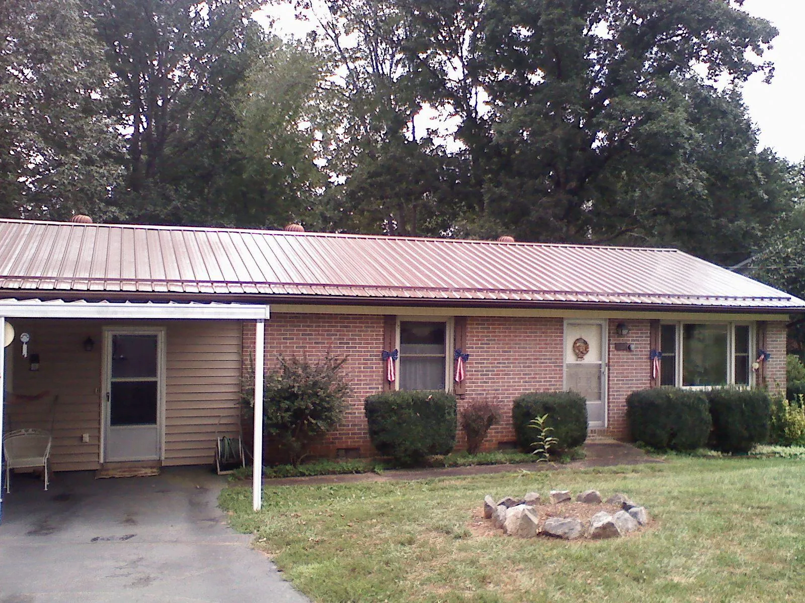 Bronze metal roof and carport on a brick ranch home — Roof Repair work by our crew in Parkhill