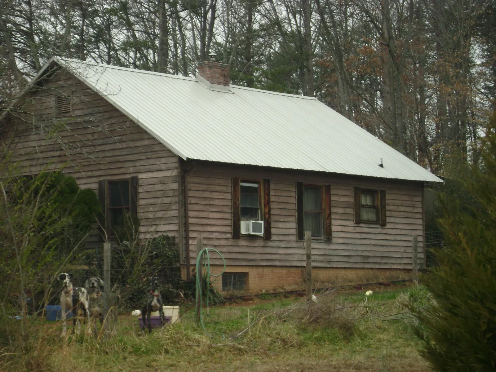 White metal roof on an old wood sided farmhouse, from a Metal Roof Installation job in Parkhill